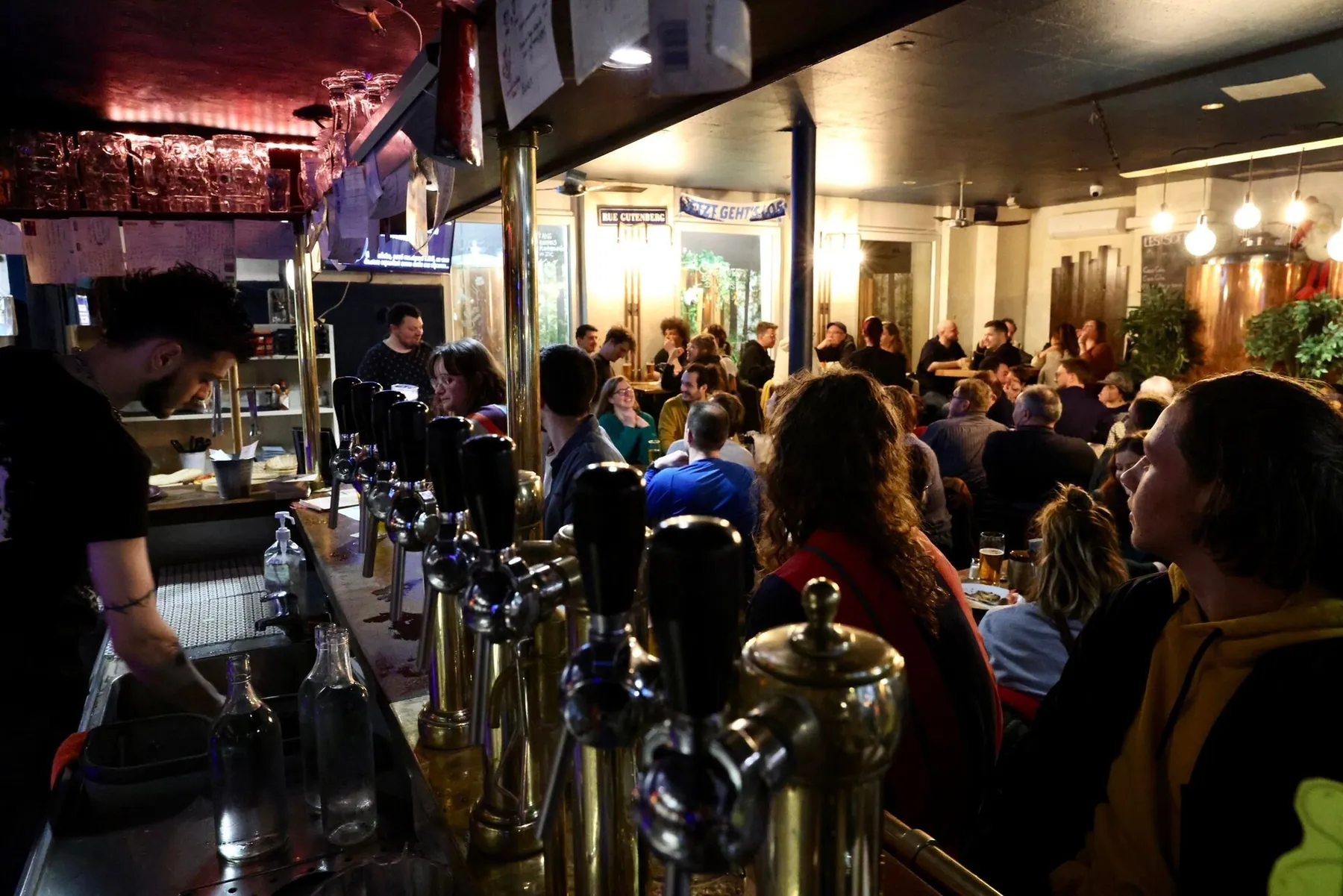 Le comptoir de La Lanterne et ses tireuses en laiton, un soir de grande affluence