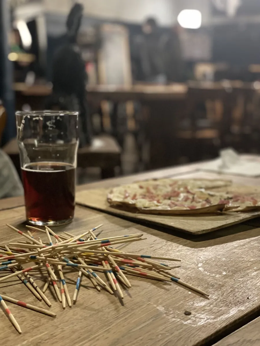 Une partie de mikado à côté d'une tarte flambée